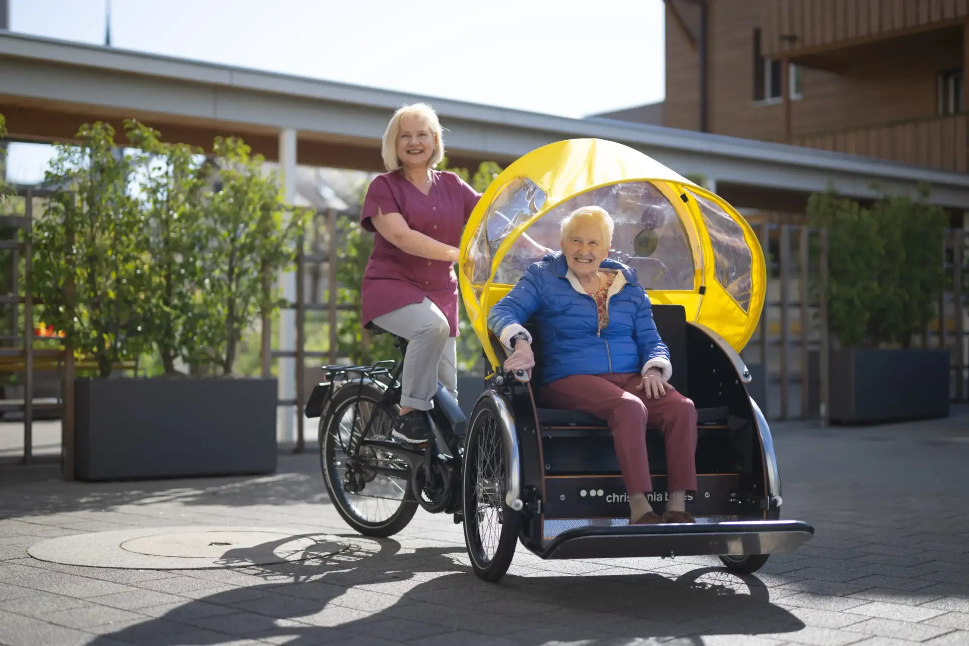 mitarbeiterin-faehrt-aeltere-dame-fahrrad-heimet