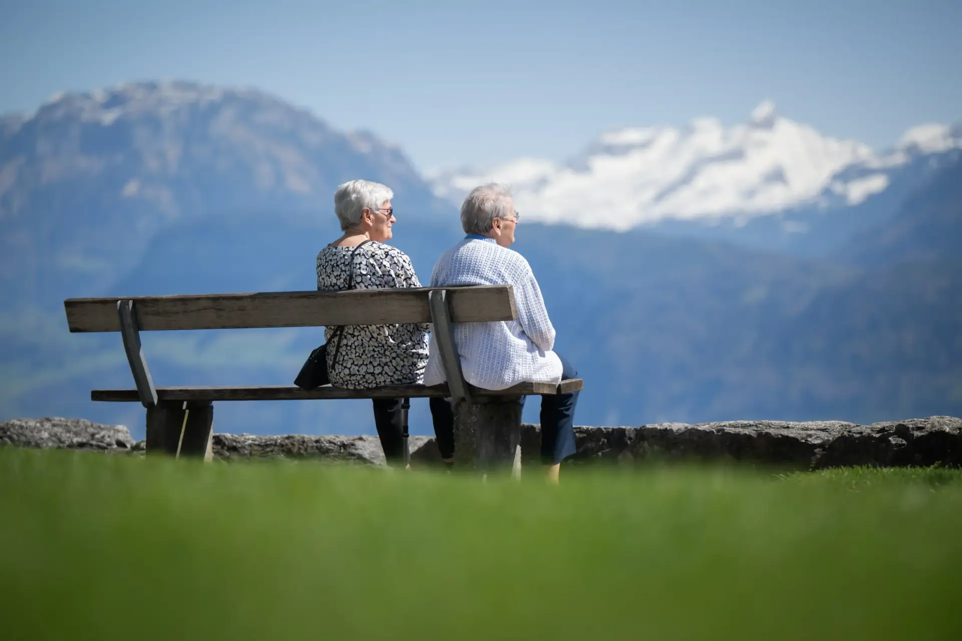 damen-sitzen-auf-bank-aussicht-alpen