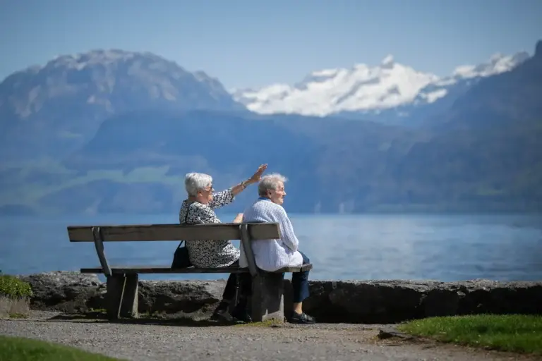 eltere-damen-sitzen-auf-bank-geniessen-aussicht-auf-alpen-alters-und-pflegeheim-heimet